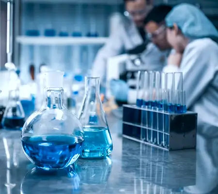 Laboratory with blue flasks and researchers representing the chemistry industry